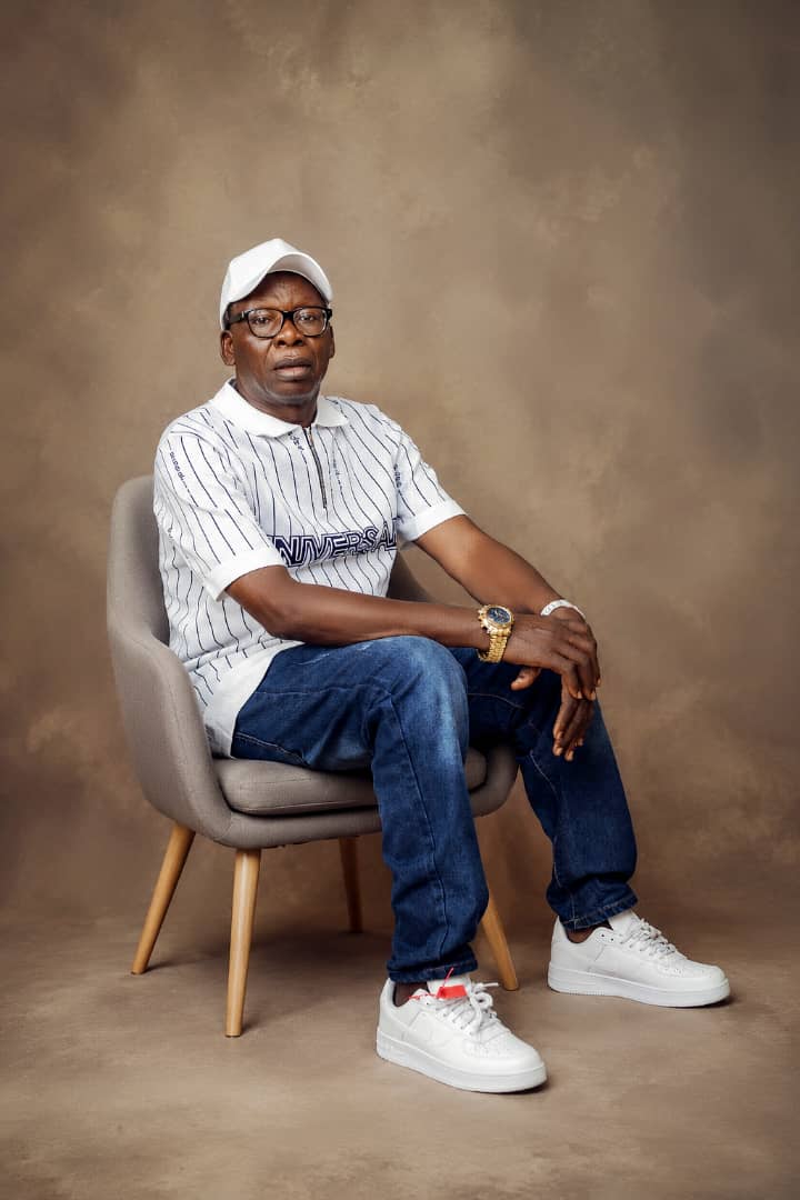 Man in a white polo and cap seated casually in the studio