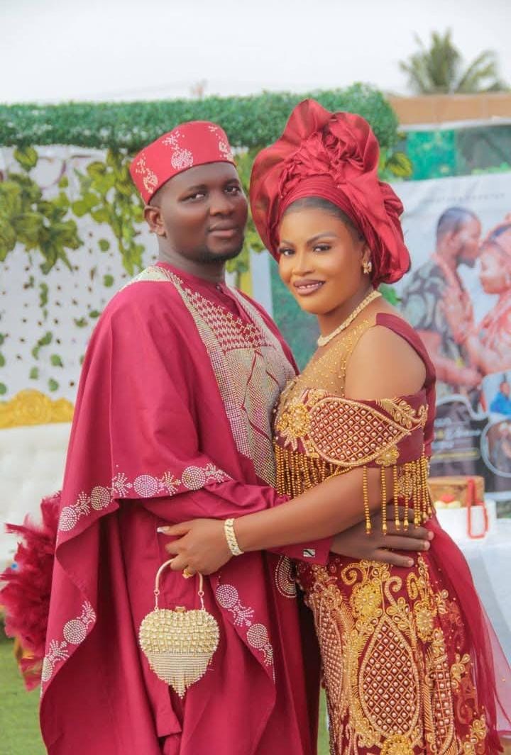 Couple embracing in red and gold traditional wedding attire