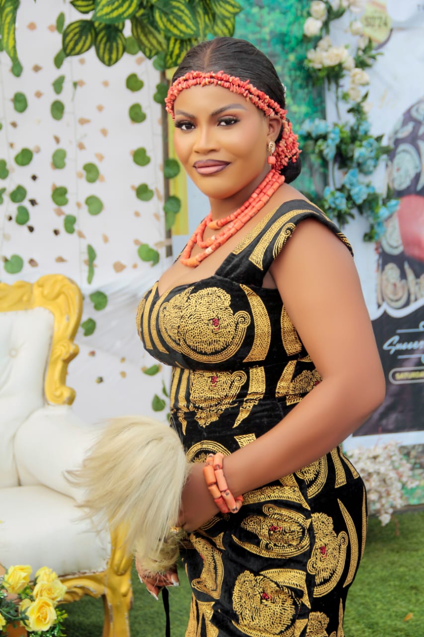 Woman in black and gold traditional attire with coral beads