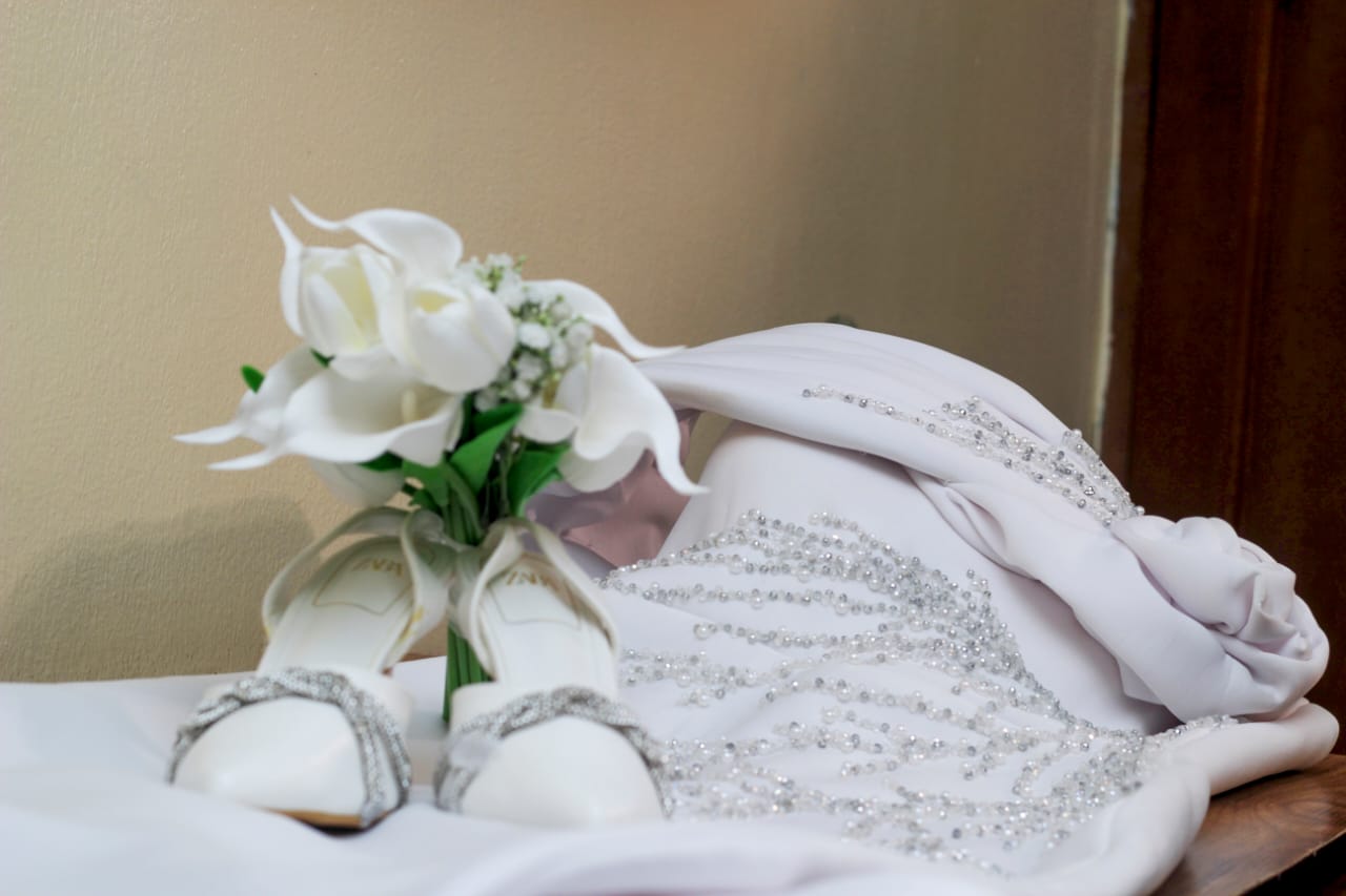 Close up of wedding shoes, bouquet and beaded dress detail
