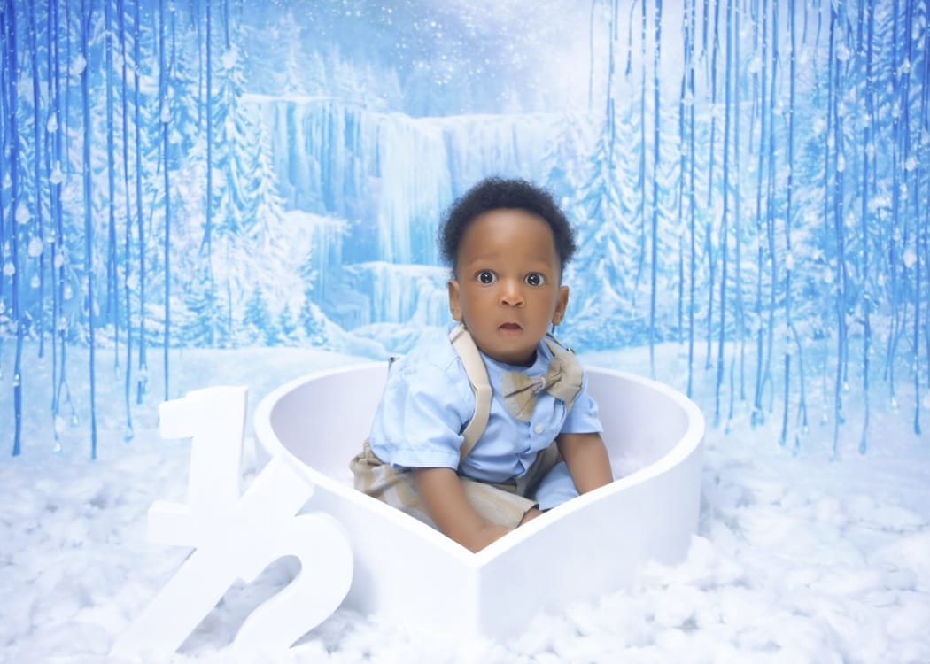 Baby boy in a heart-shaped basket for a half-birthday winter themed shoot